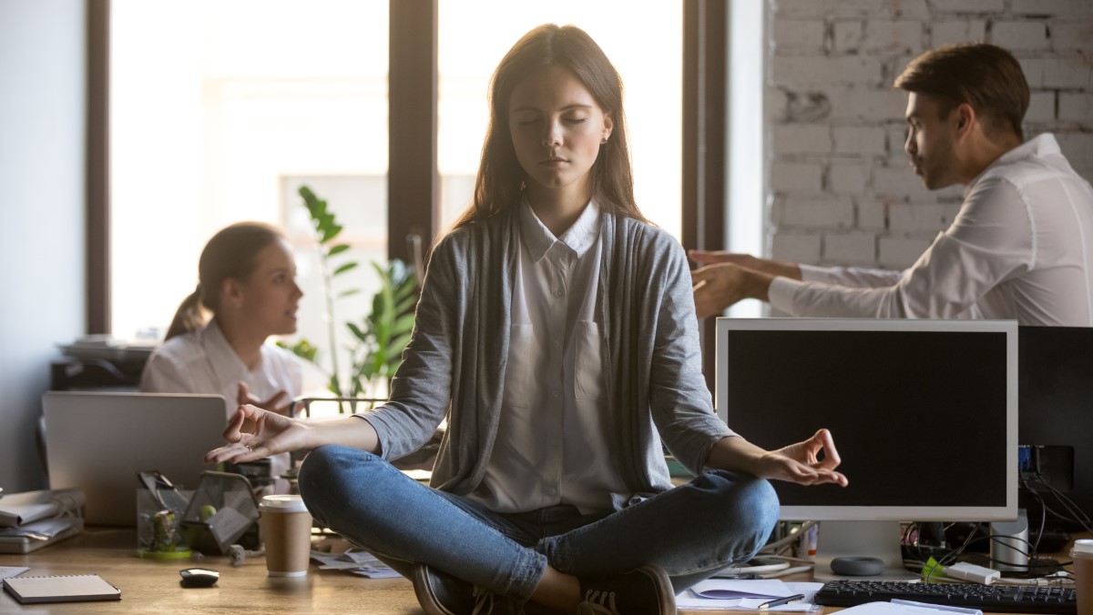 Woman meditates to better manage her anxiety in the work place