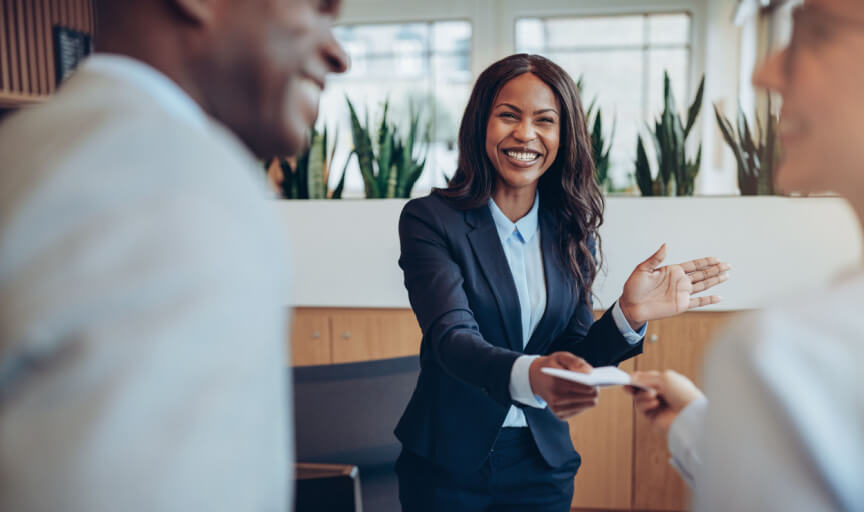 Customers engaged in conversation with staff member at a hotel reception.