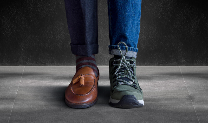 Image showing an individual employee's legs, one leg in formal attire and wearing a shoe and the other in jeans and wearing a sports shoe, to illustrate the concept of work-life balance.