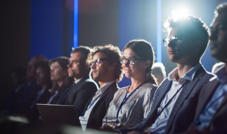 Delegates at a conference listen attentively during a speaker session.